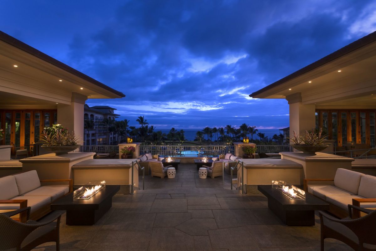 a patio with a pool and a building with a view of the ocean