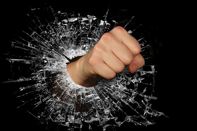 a fist breaking through a broken glass