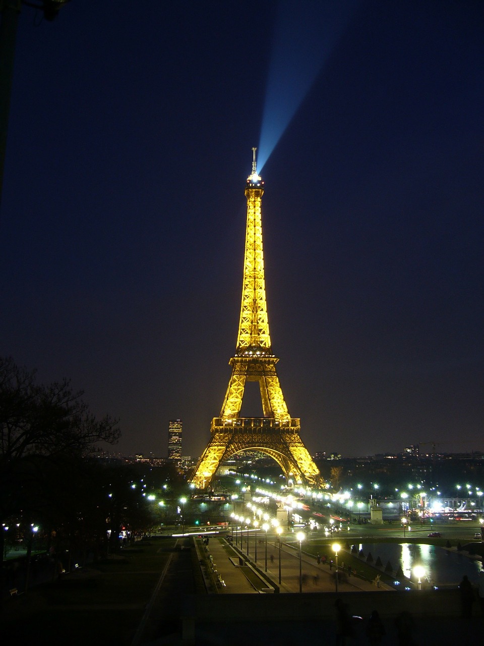 a tall tower lit up at night with Eiffel Tower in the background