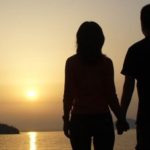 a silhouette of a couple holding hands