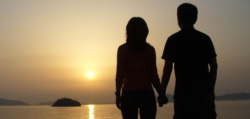 a silhouette of a couple holding hands
