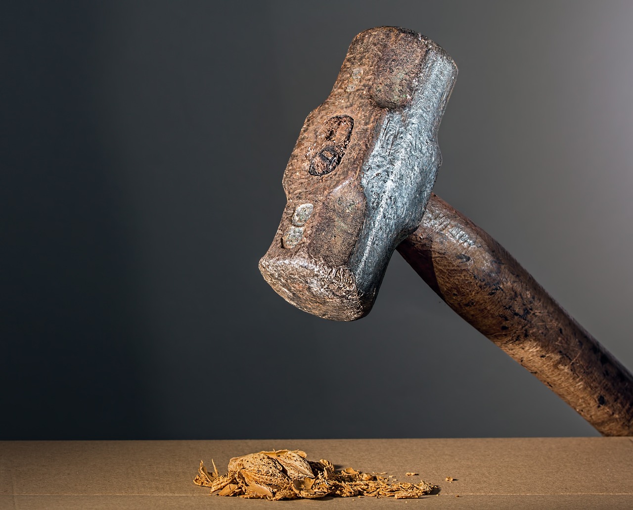a hammer hitting a pile of dirt