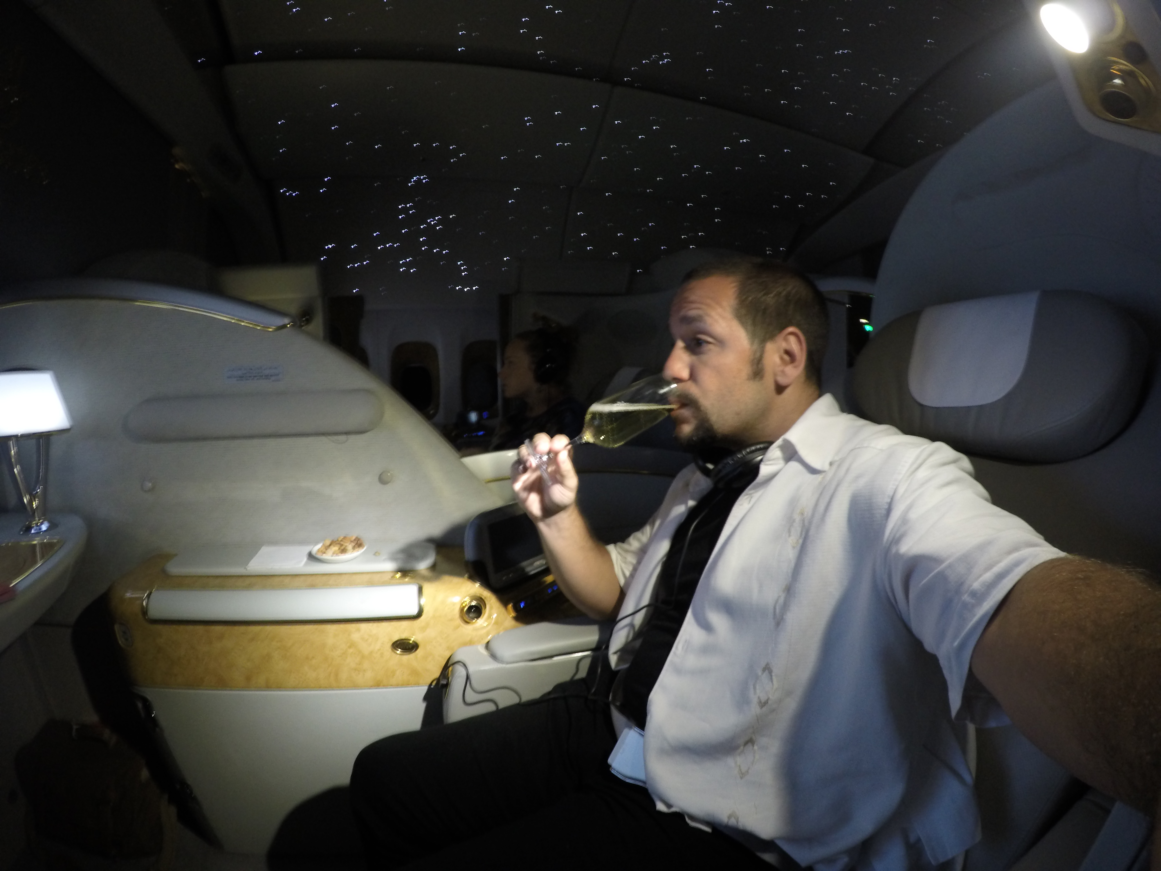 a man drinking from a glass in a plane