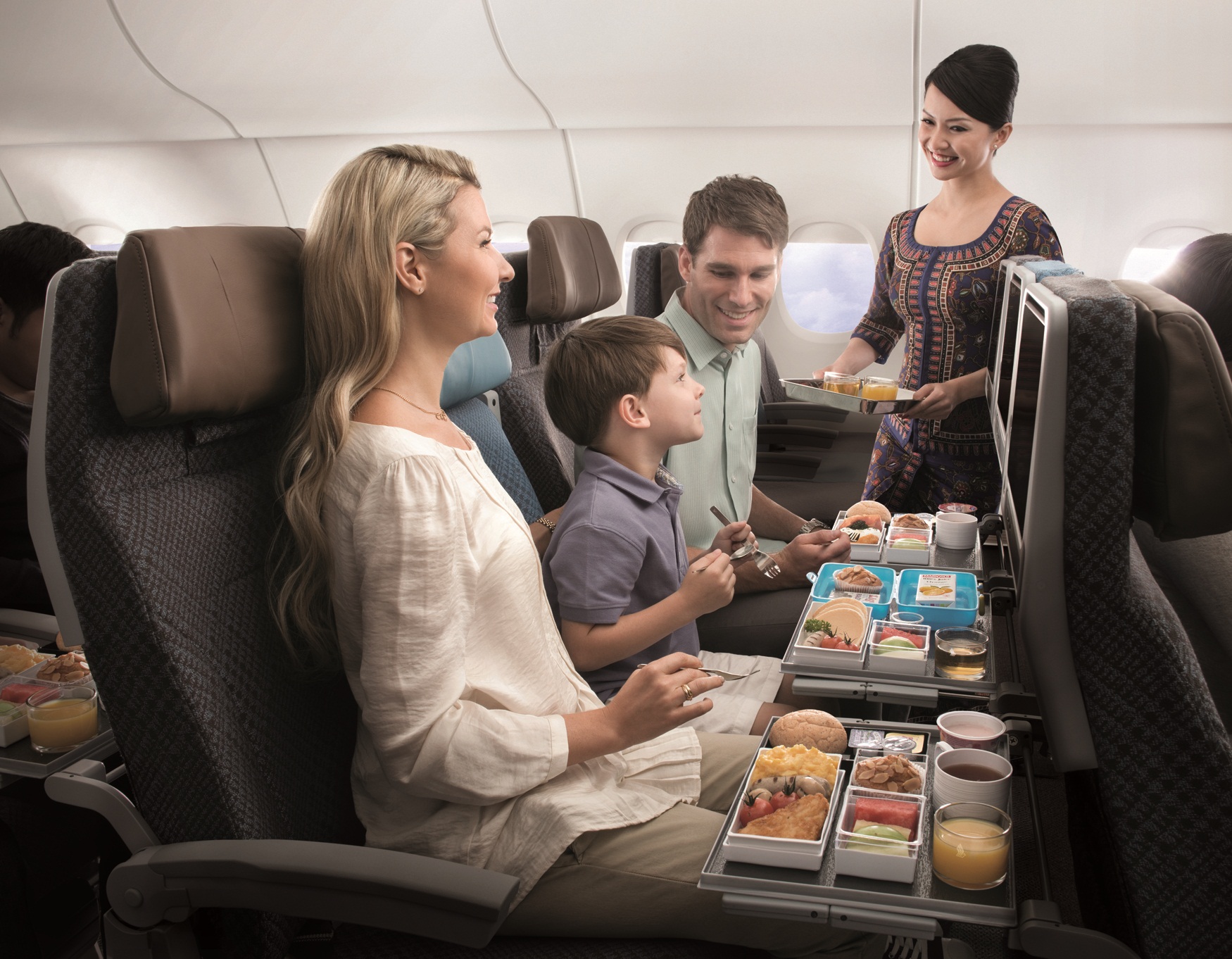 a family on an airplane eating food