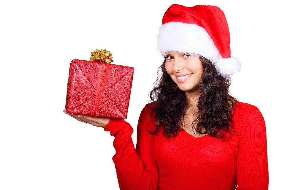 a woman wearing a santa hat and holding a present
