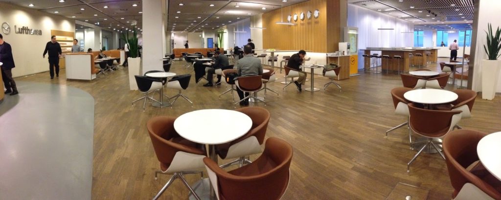 people sitting in a room with tables and chairs