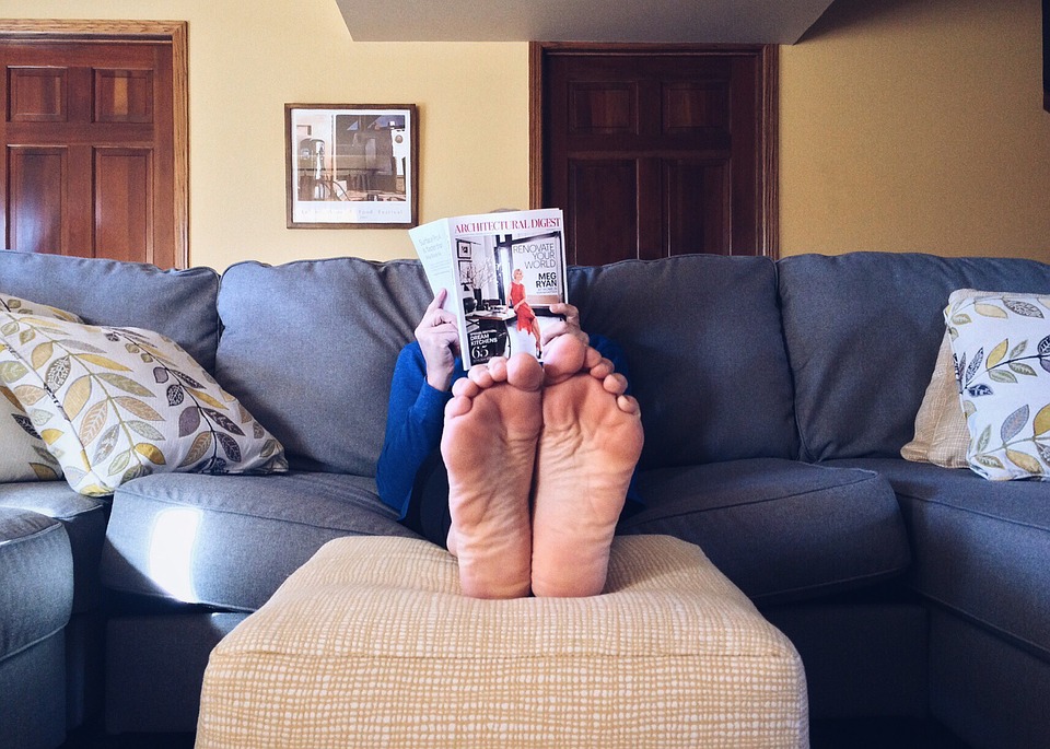 a person reading a magazine on a couch