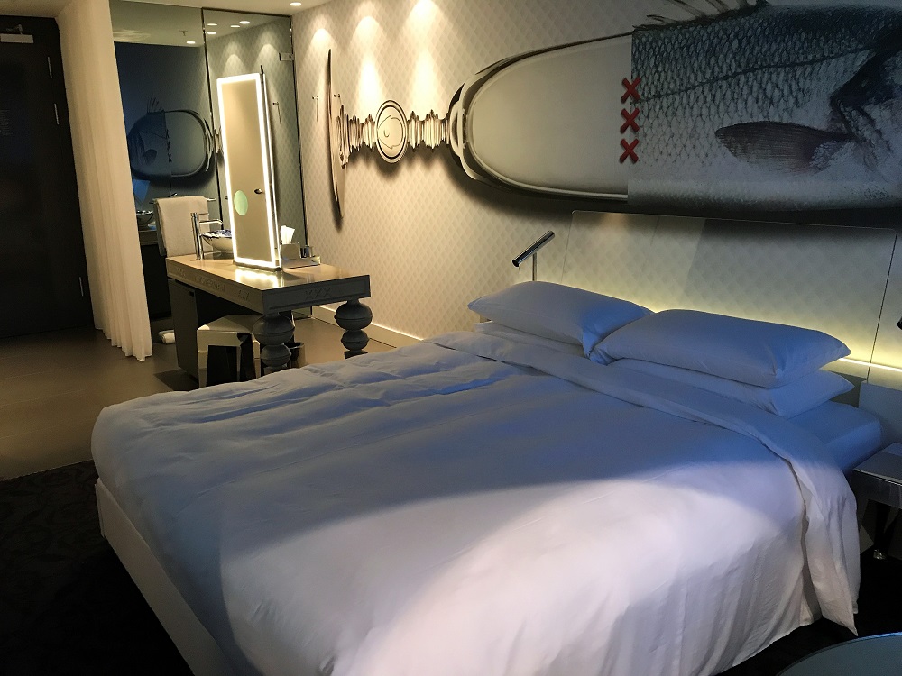 a bed with a mirror and a fish on the wall