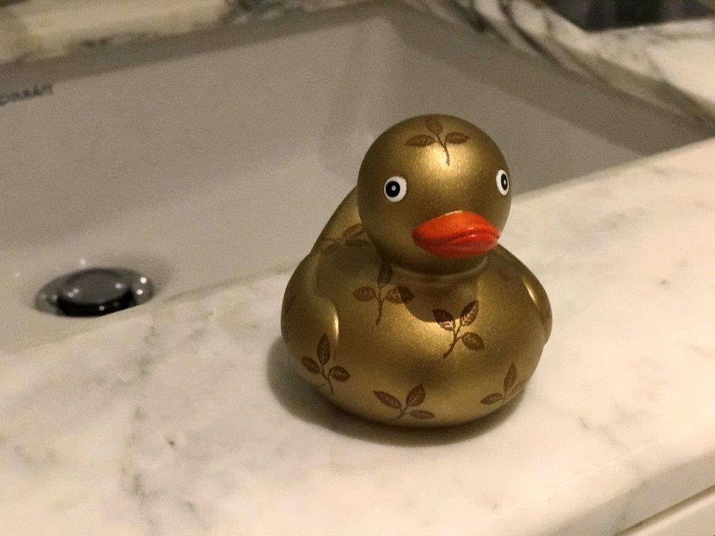 a golden rubber duck on a marble counter