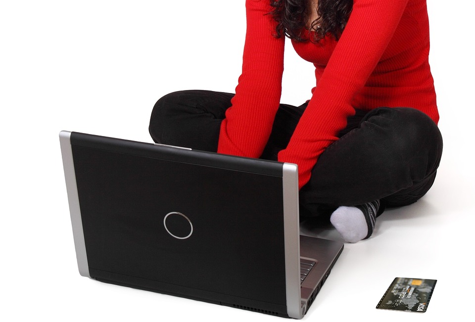 a woman sitting on the floor with her laptop