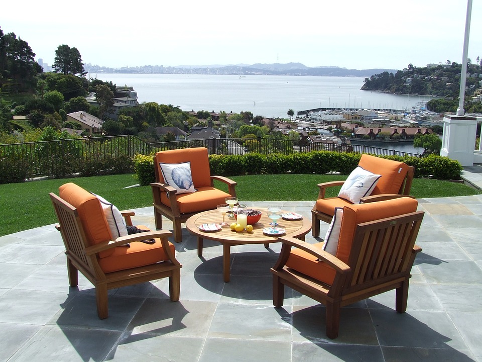 a patio with chairs and a table overlooking a body of water
