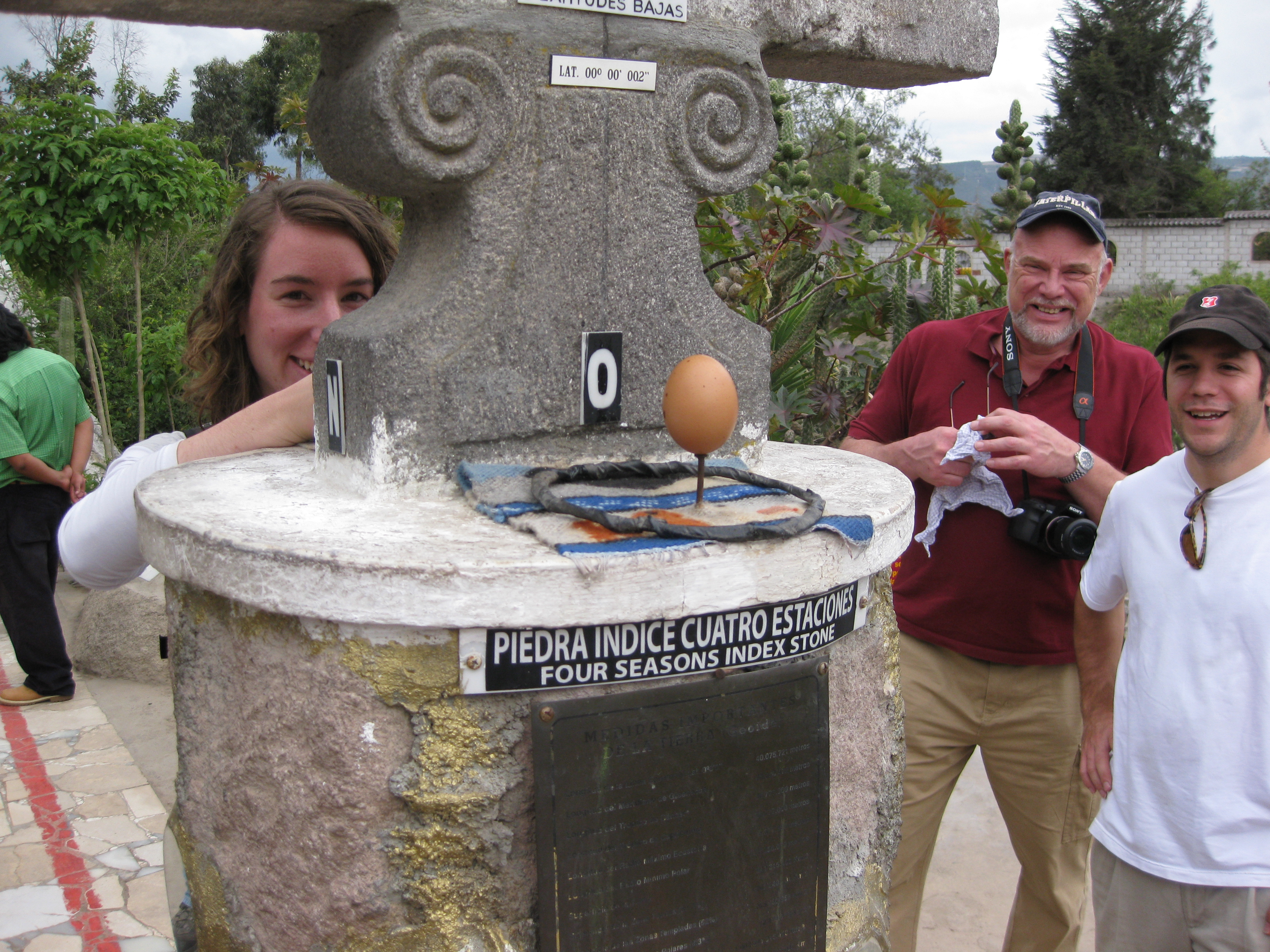 a man and woman standing next to a stone fountain
