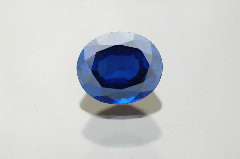 a blue gem on a white surface