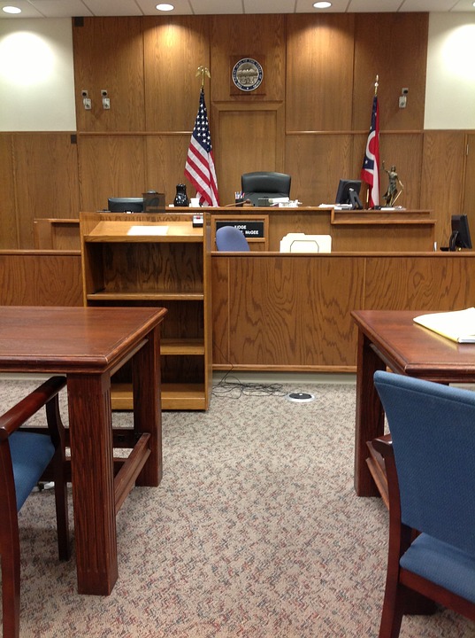a courtroom with a flag and a chair