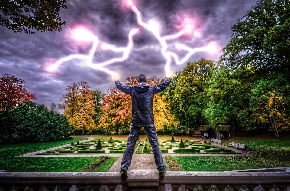 a man standing on a ledge with lightning bolts in the sky