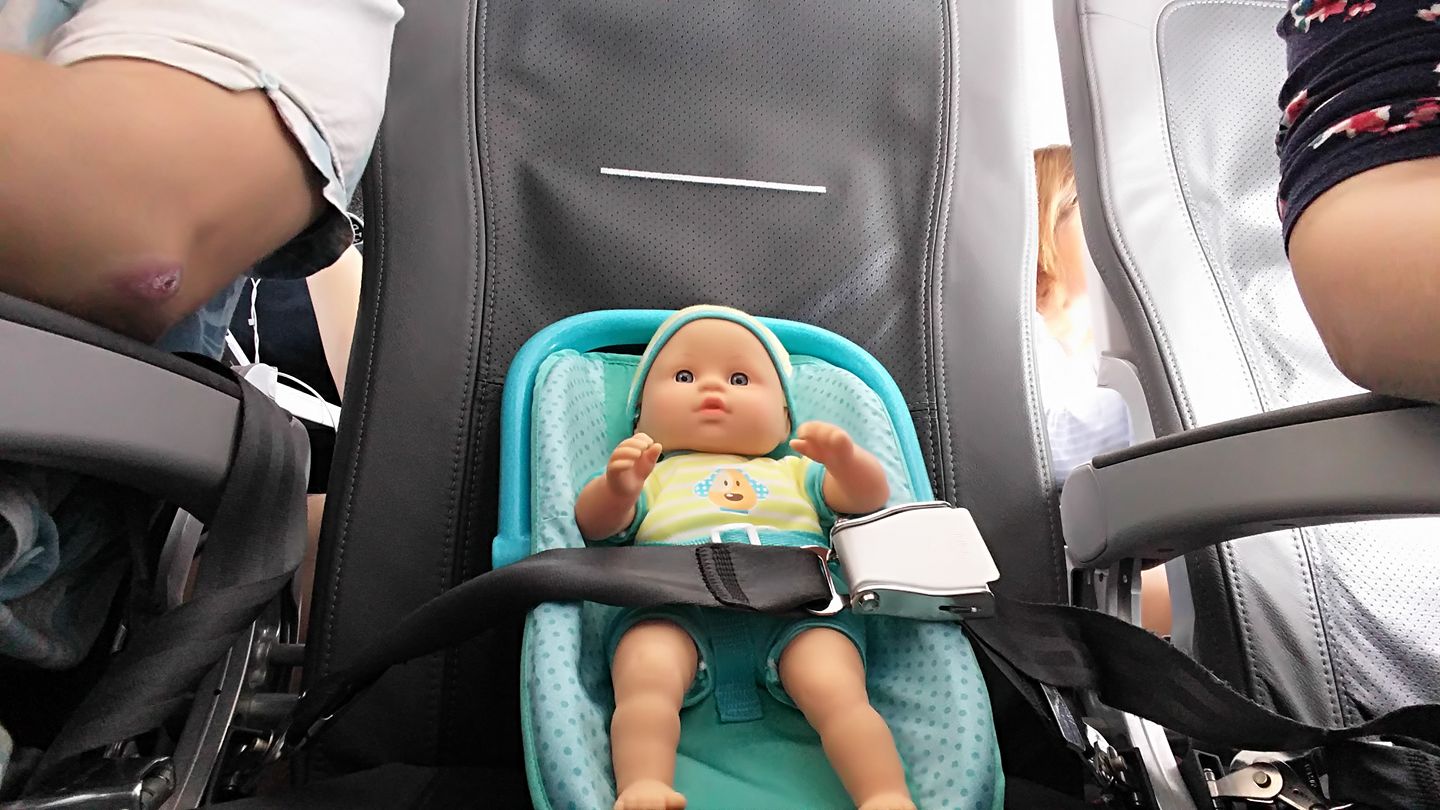 a baby doll in a car seat