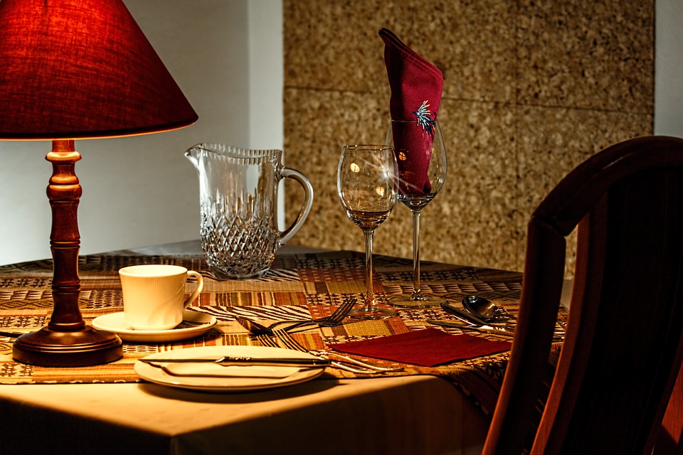 a table with wine glasses and a lamp