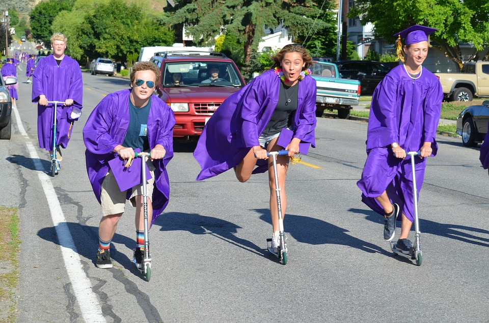 a group of people wearing purple robes and riding scooters