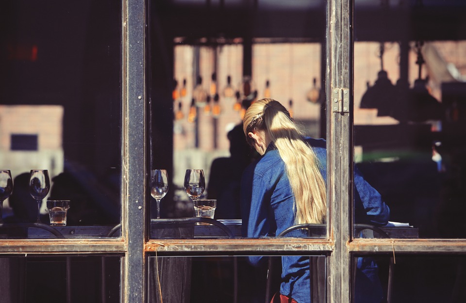 a woman sitting at a table with wine glasses