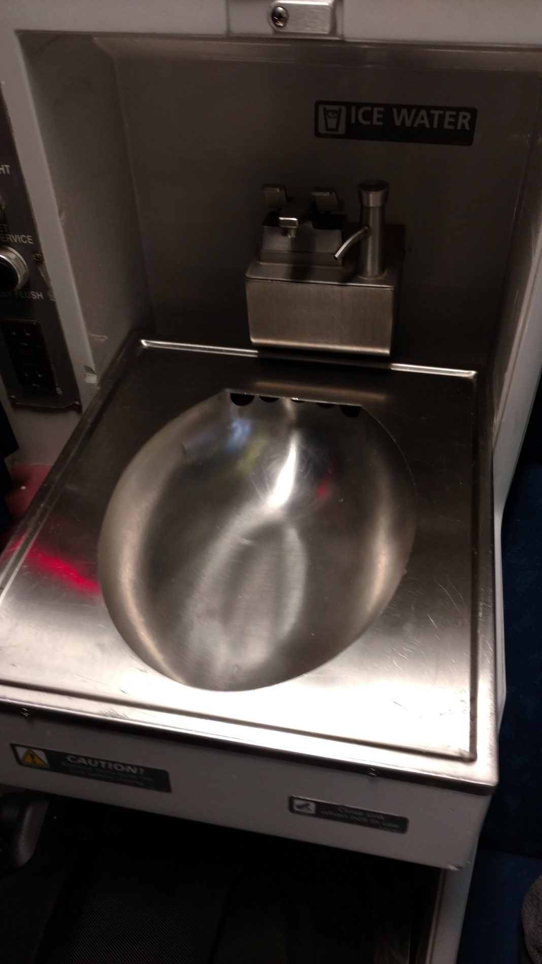 a silver sink with a soap dispenser