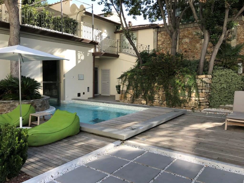 a pool with a deck and a stone wall