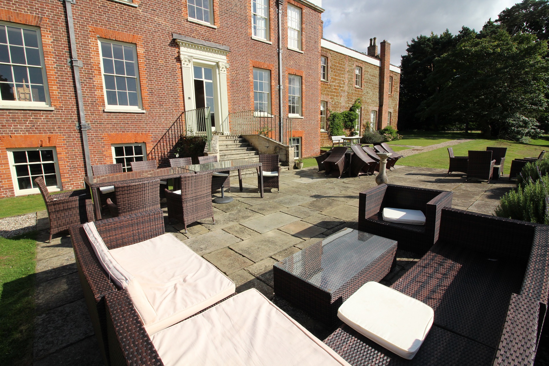 a patio area with chairs and tables outside of a brick building