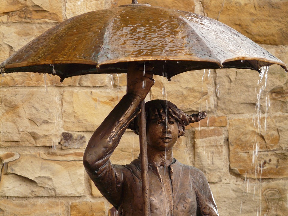 a statue of a woman holding an umbrella
