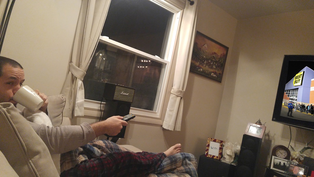 a person sitting on a couch holding a remote control
