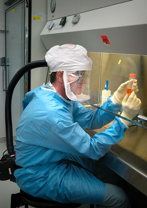a man in a protective suit and hat working in a laboratory