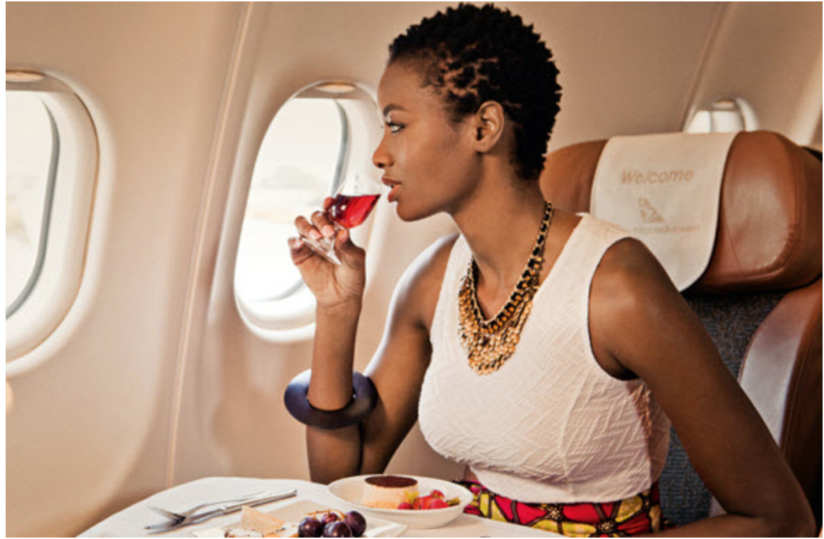 a woman drinking wine on an airplane