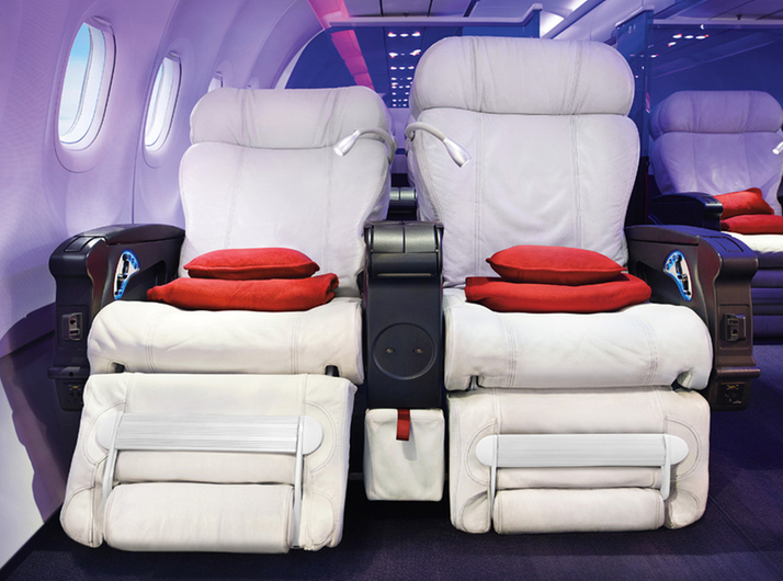 a white chairs with red pillows in the middle of the plane