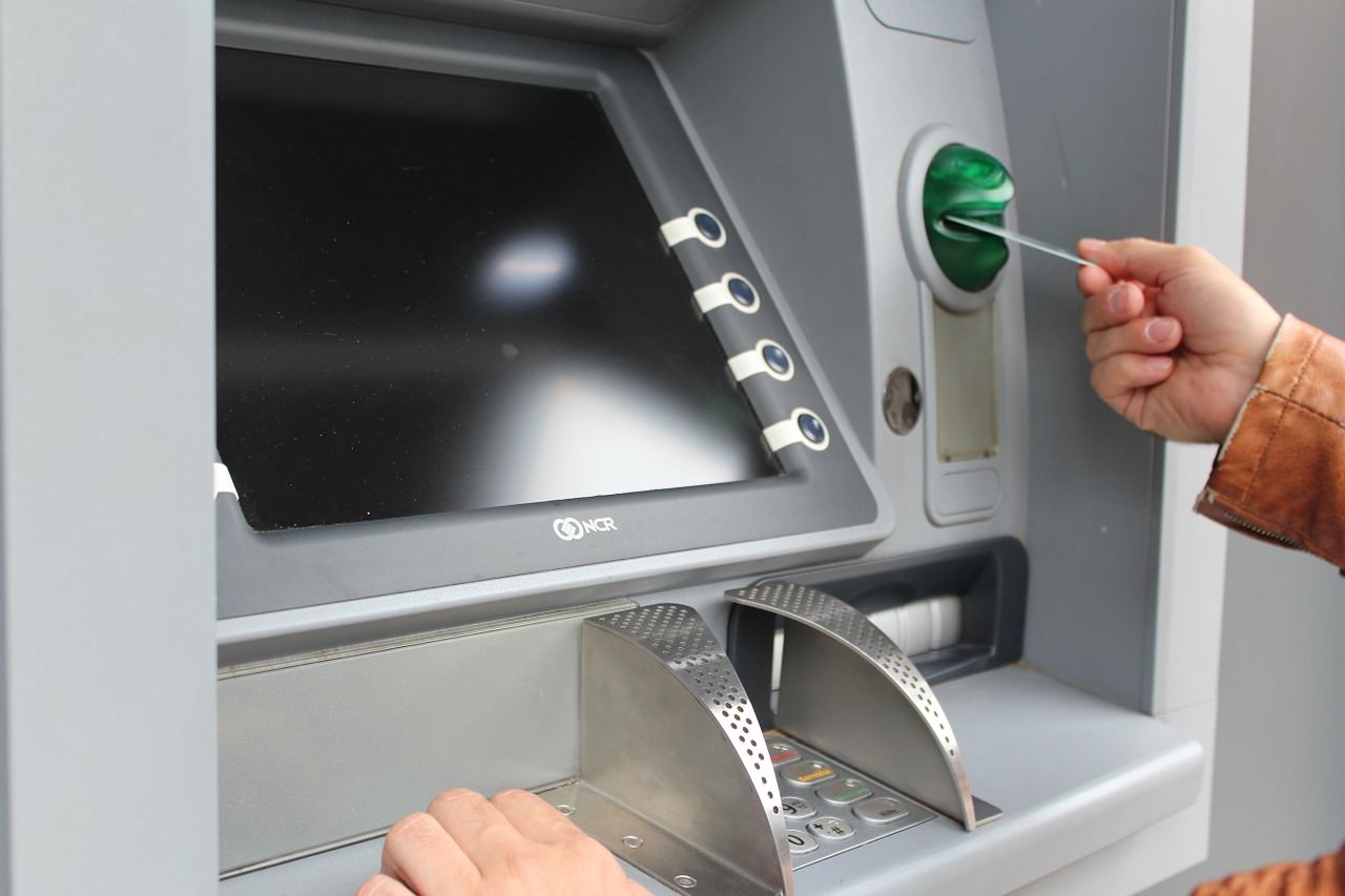 a person using a credit card to insert a card into an atm