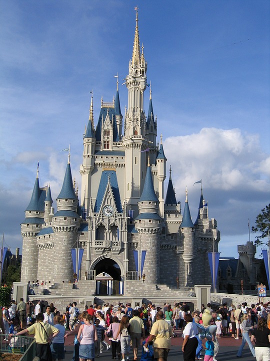 a castle with people in front of it with Magic Kingdom in the background