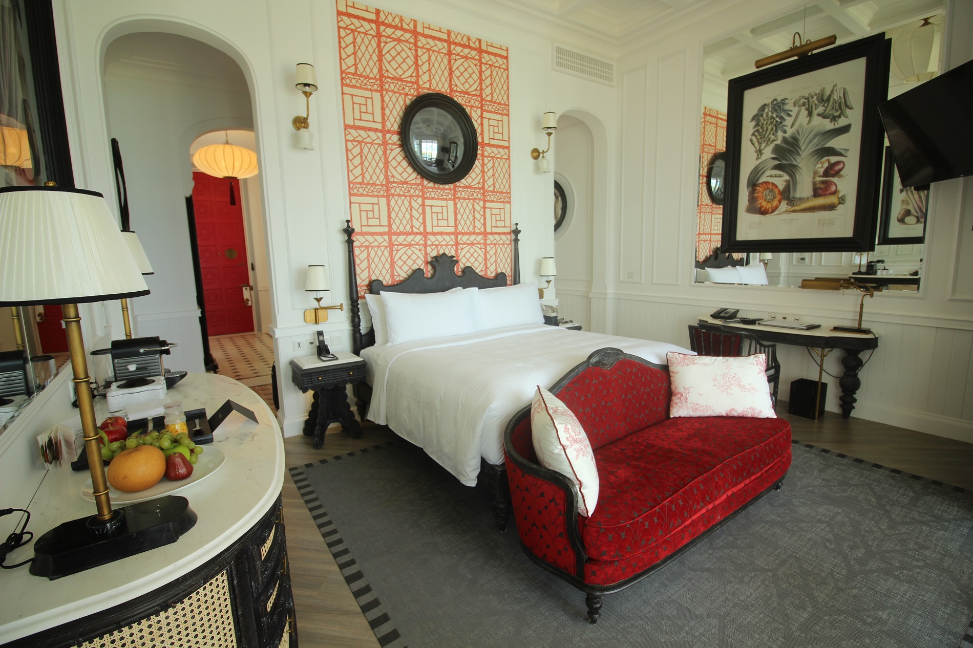 a bedroom with a red couch and a mirror