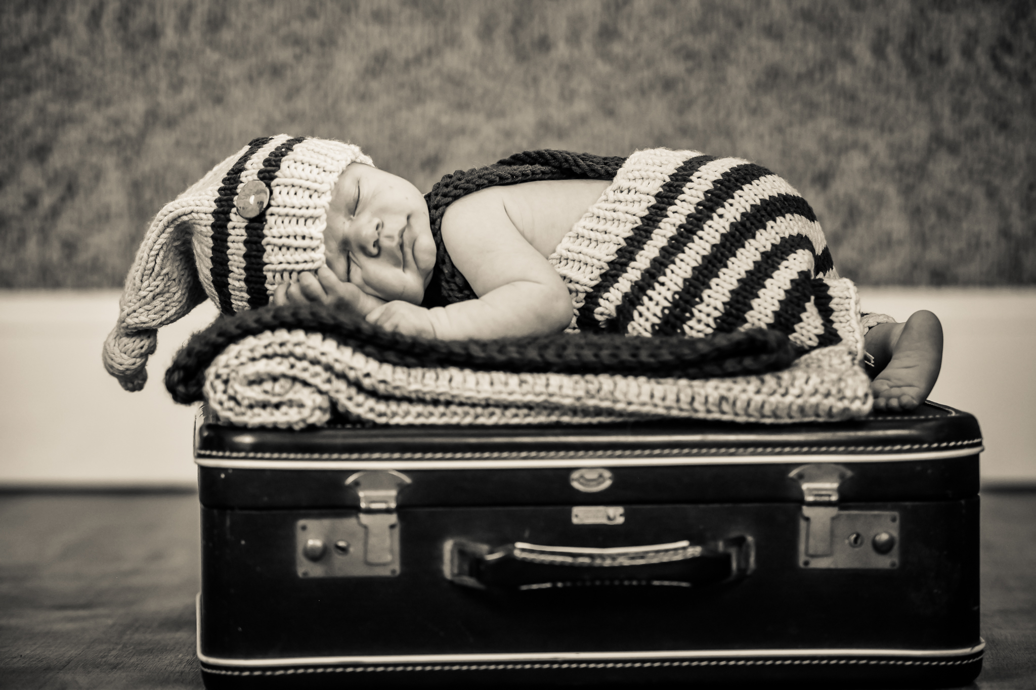 a baby sleeping on a suitcase