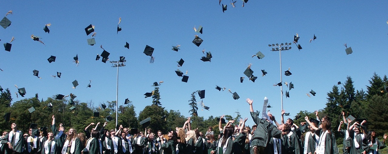 a group of graduates throwing caps in the air