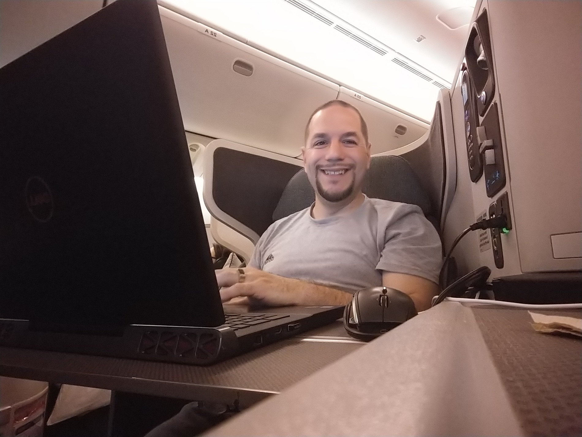 a man sitting in an airplane with a laptop