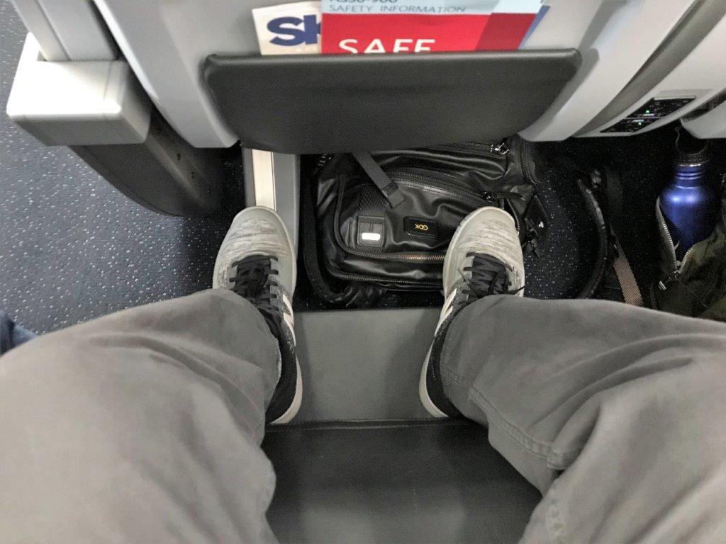 a person's legs in grey pants and grey shoes
