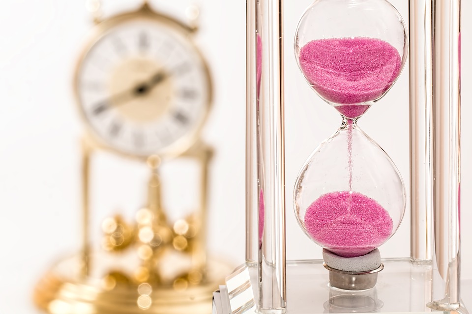 a hourglass with pink sand running through it