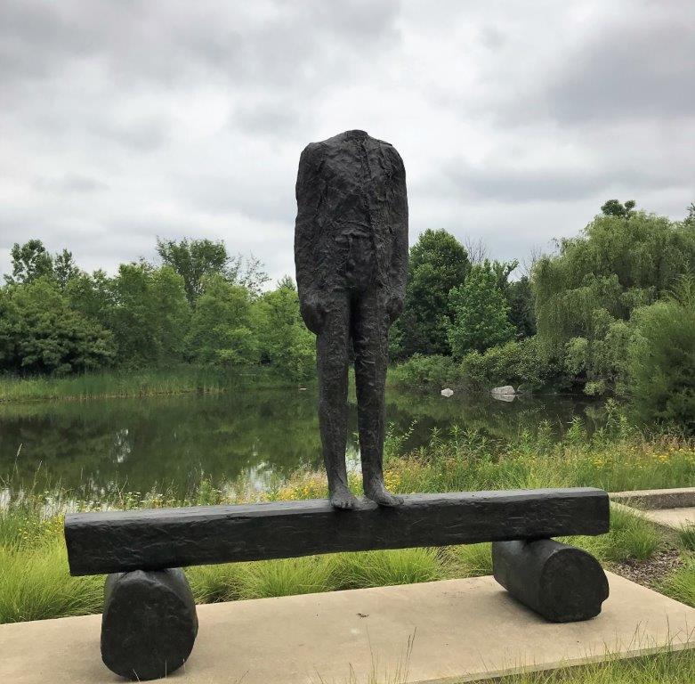 a statue of a person standing on a bench