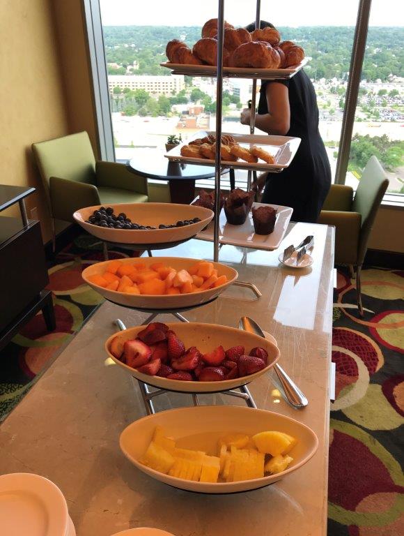 a buffet with many plates of fruit and muffins