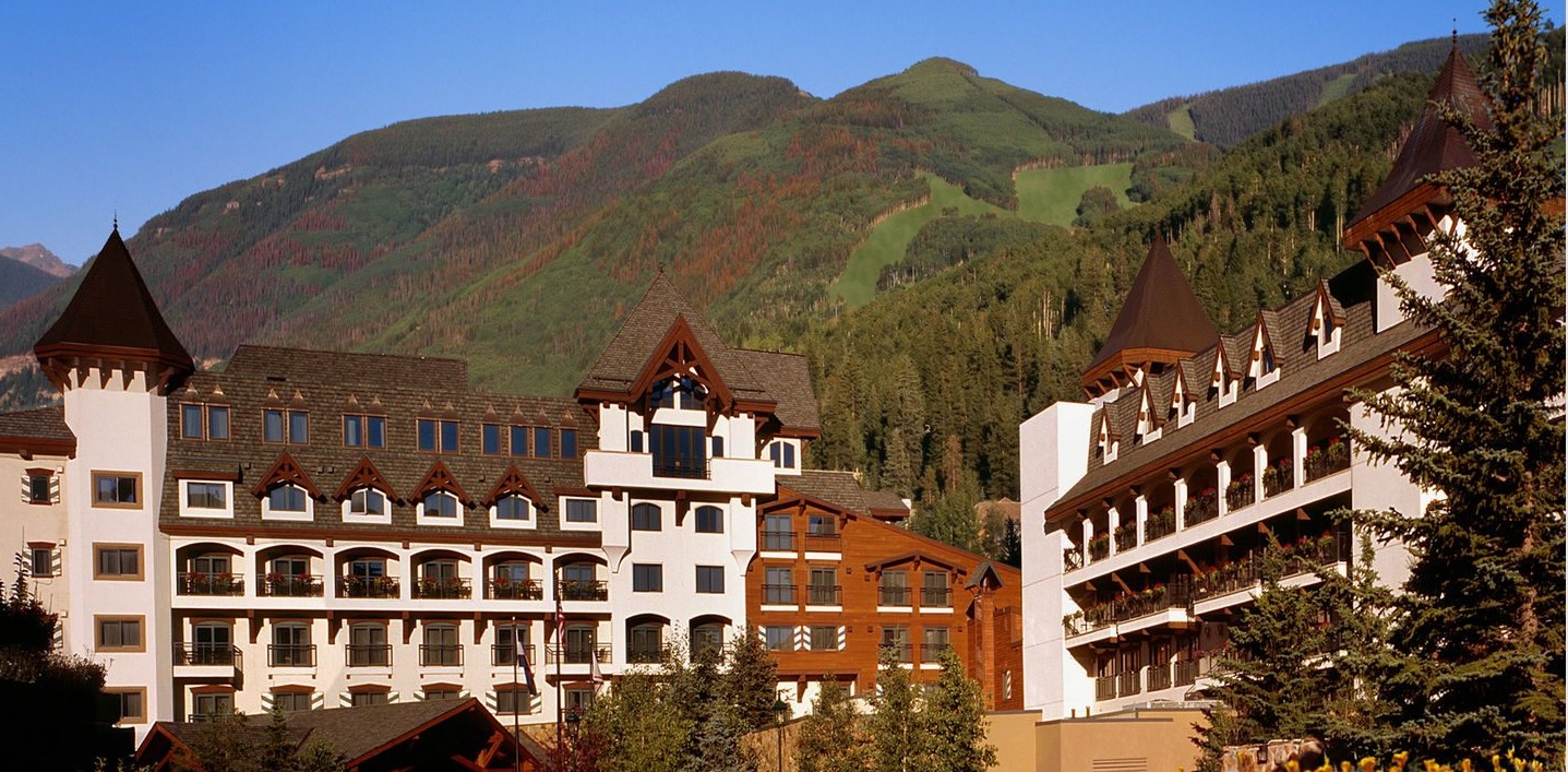 a group of buildings with mountains in the background