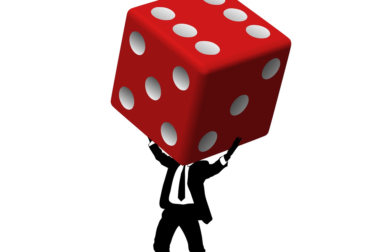 a man in a suit and tie holding a large red dice