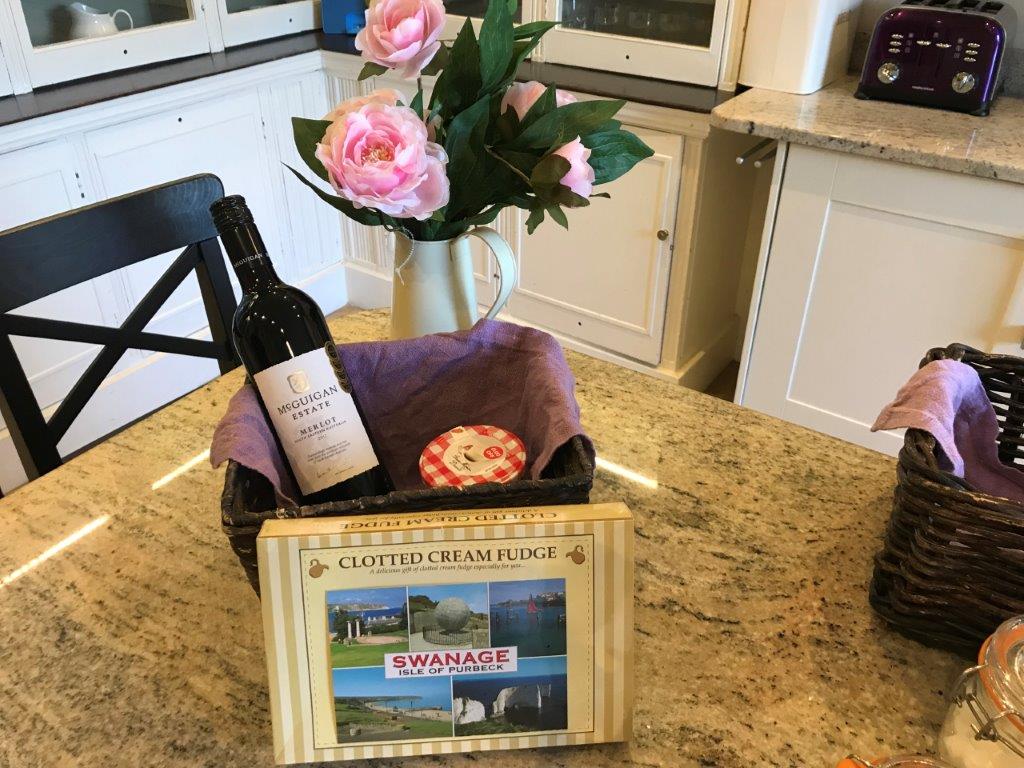 a basket of wine and a box of cheese on a kitchen counter