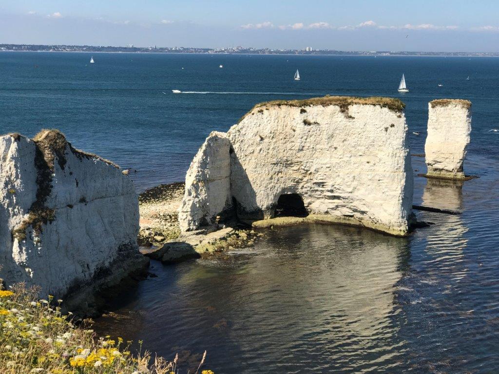 a white cliffs with a hole in the middle of the water