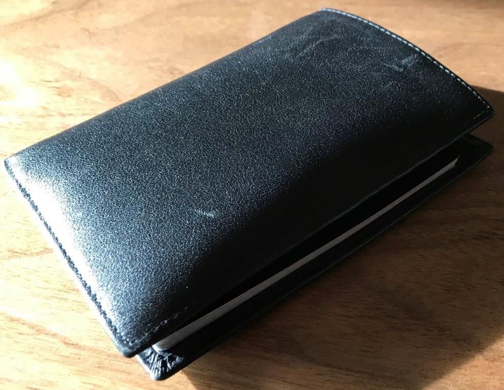 a black leather wallet on a wood surface