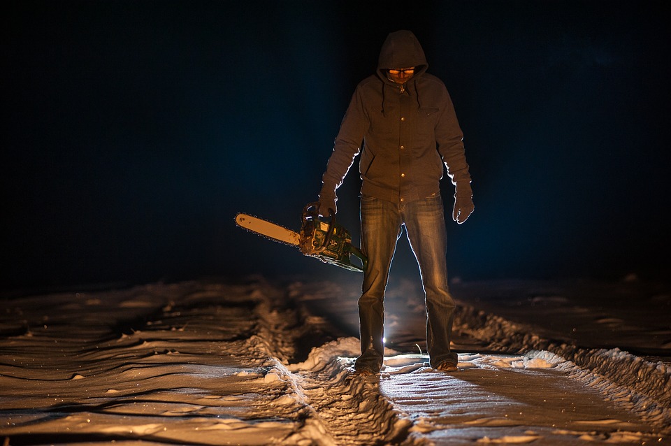 a man holding a chainsaw in the snow