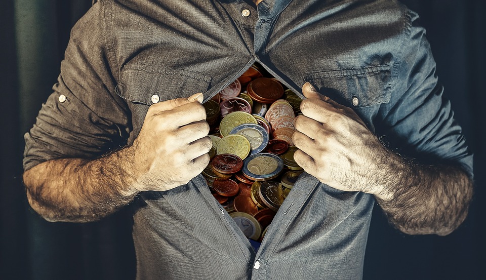 a man opening his shirt with coins inside
