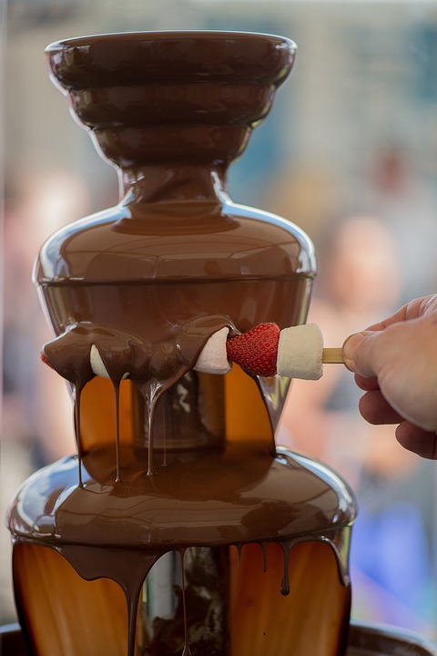 a chocolate fountain with strawberries and marshmallows
