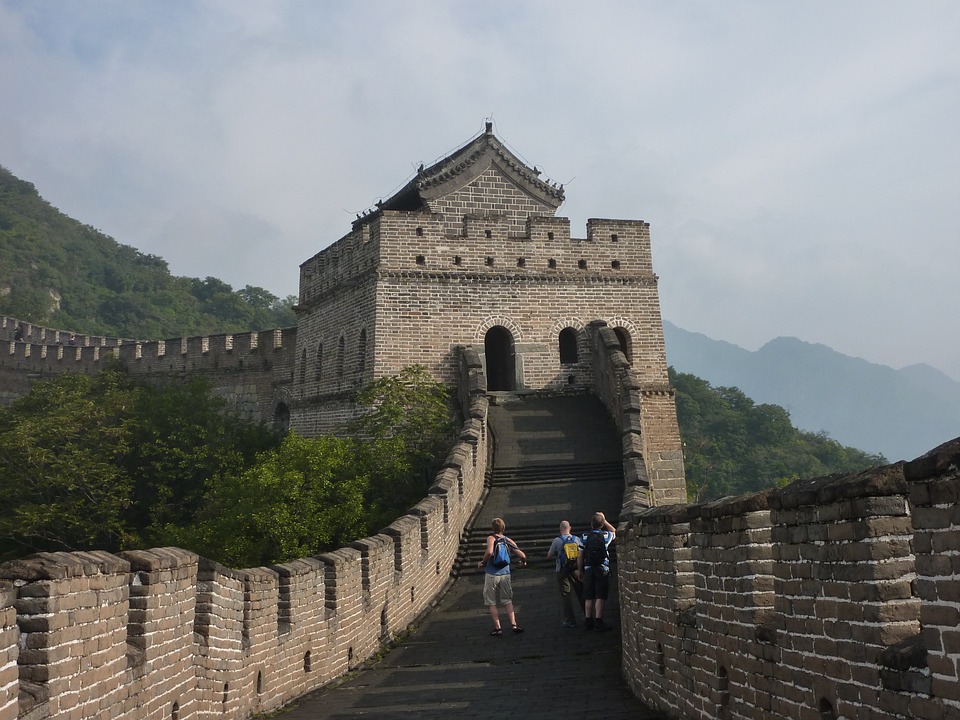 people walking on a stone wall with Great Wall of China in the background